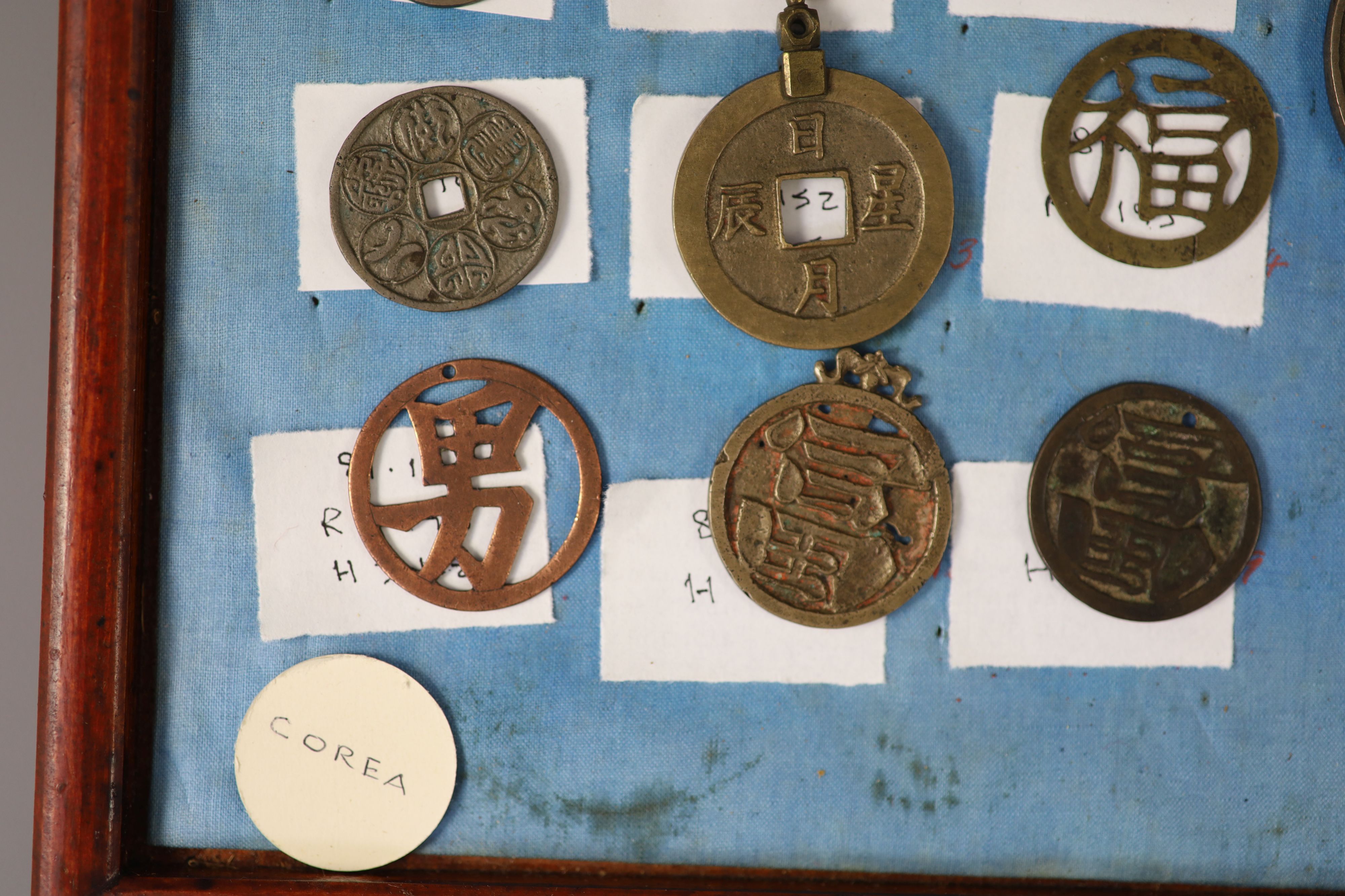 A group of 99 Korean bronze and metal amulets or charms, 19th/20th century